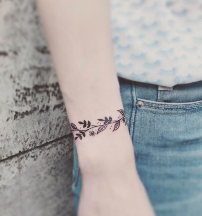 moters tatuiruotė, apyrankė ant riešo, šaka su gėlių raštais, gėlėmis ir lapais, moteriškas papuošalų dizainas