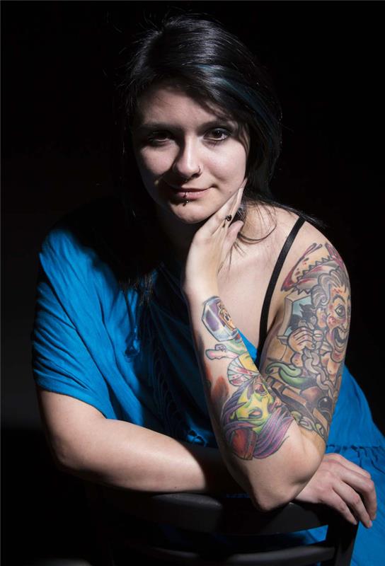 barvna tetovaža stripovska roka za rjavolasko z modro obleko od rame do zapestja