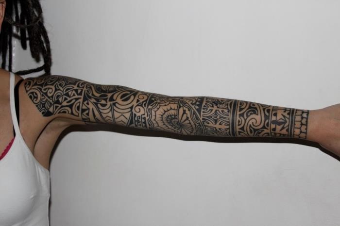 ženski model tetovaže, risba po celotni roki z etničnimi motivi, simbolična tetovaža z geometrijskimi vzorci