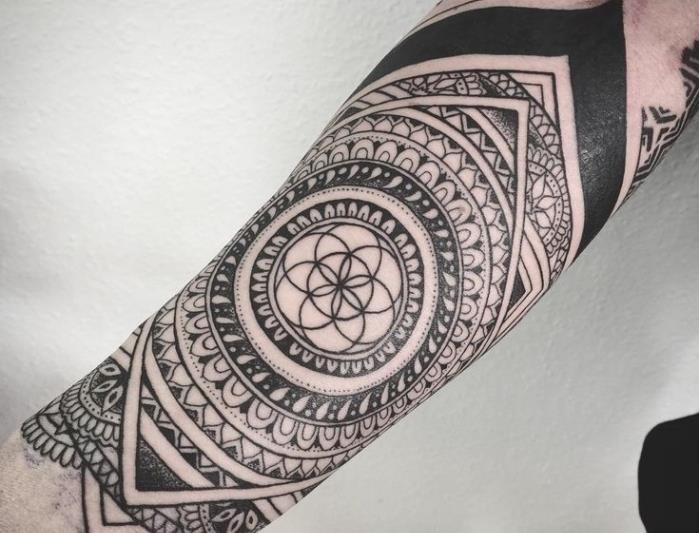 moška tetovaža, risba s črnilom na roki v oblikovanju mandale z geometrijskimi vzorci