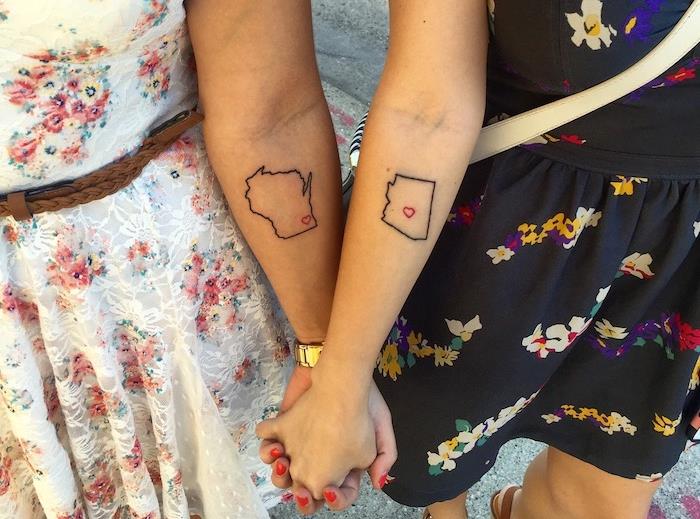 draugystės tatuiruotė, merginos baltomis ir juodomis suknelėmis su įvairiaspalviais gėlių raštais, simbolinė draugystės tatuiruotės idėja