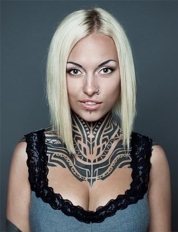 plemenska tetovaža na vratu, etnični vzorci črnega črnila, blondinka, piercing nosu in ustnic, čipkasta majica