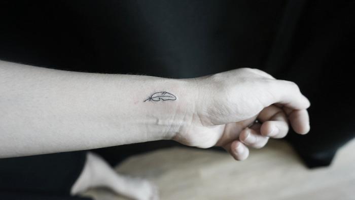 maža tatuiruotė, rašalo piešimas ant riešo, diskretiška plunksnų tatuiruotė