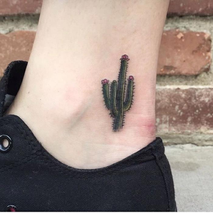 diskretiška tatuiruotė, mažas kaktusas su violetinėmis gėlėmis tatuiruotas tiesiai virš kulkšnies