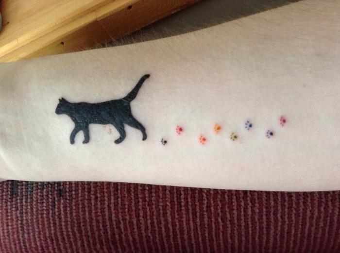 tetovaža z odtisom, pisane tace in črna mačka, ki hodi po podlakti