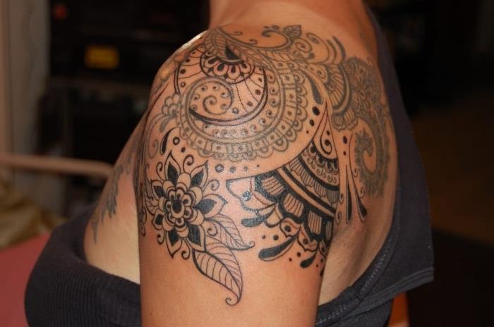 tetovirana ženska, risba s črnilom na rami in hrbtu z etničnim cvetjem in oblikovanjem mandale