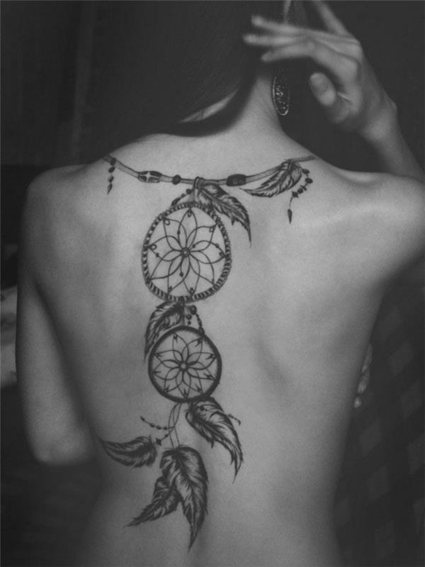 tatu ženska, tetovaža na hrbtu z obliko podružnice in lovilci sanj z etničnim perjem