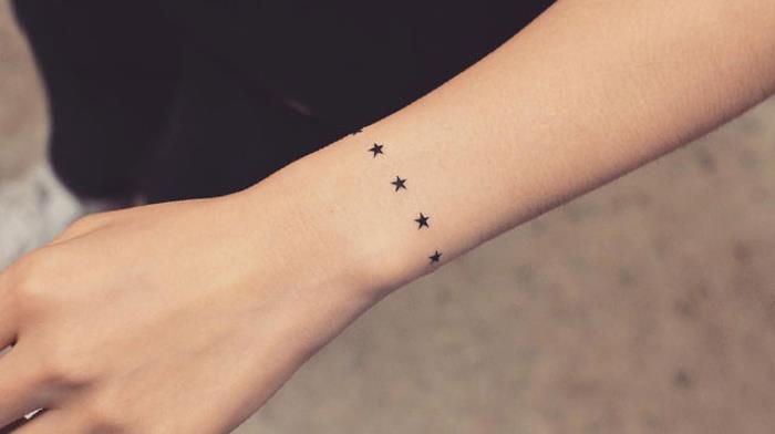 Moteriška riešo apyrankės tatuiruotė, juodos rožančiaus žvaigždės, moteriškos tatuiruotės idėja