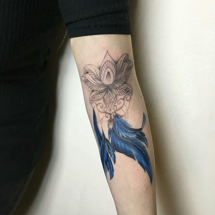 plunksnų tatuiruotė, juoda palaidinė su vidutinio ilgio rankovėmis, gėlių dizaino tatuiruotė ant rankos su spalvingomis plunksnomis