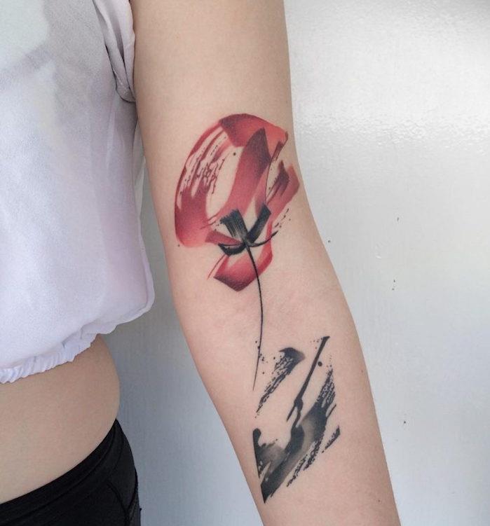 kolda kırmızı ve siyah soyut haşhaş çiçeği dövmesi