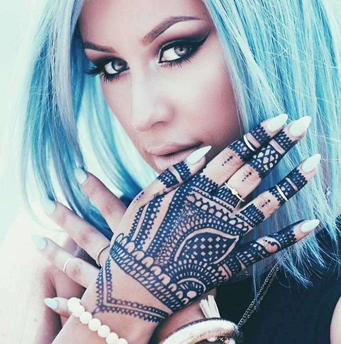 tetovaža na rokah in prstih s črno kano, ličila z zadimljenimi očmi in golimi ustnicami z modrimi lasmi