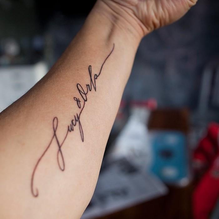 tetovaža z imenom na podlakti, dve imeni, tetovirani v črni barvi, ženska pisava, minimalistična tetovaža