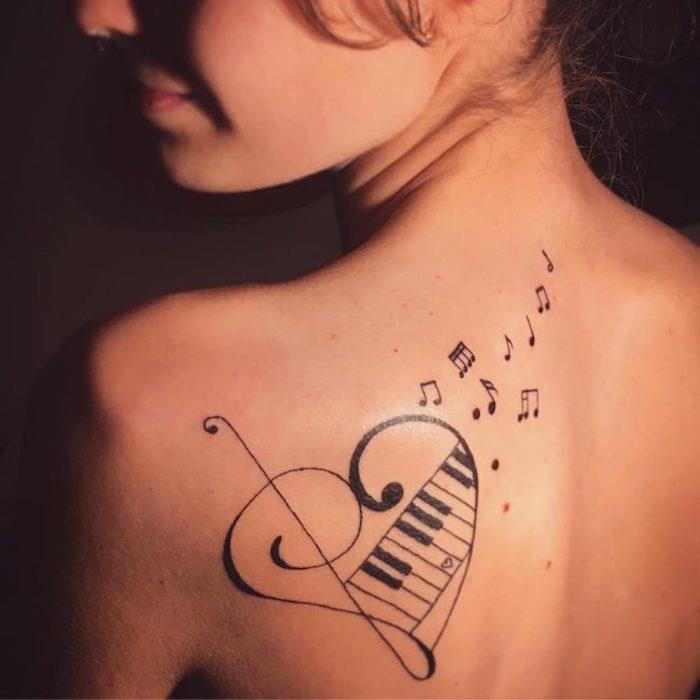tatuiruotė ant peties moteris užrašo muzikos raktų natos