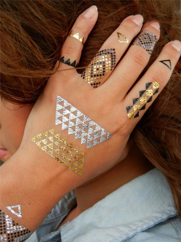 začasna tetovaža, risba na koži v črni in zlati barvi, tetovaža na rokah in prstih za žensko
