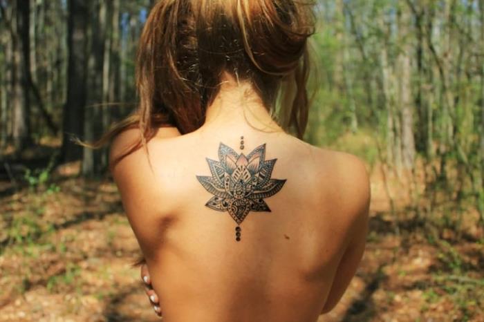ženska tetovaža, risba na hrbtu z lotosom v vzorcih mandale, body art s cvetličnimi motivi