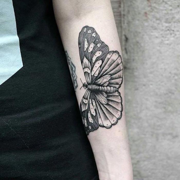 ženska tetovaža podlakti, črno -beli metulj, simbolična podoba, povezana s preobrazbo