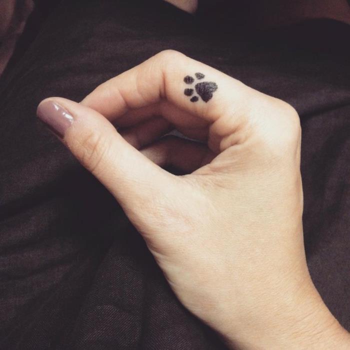 tetovaža mačje šape, mini tetovaža s prstom na palcu, tetovaža s črnim črnilom