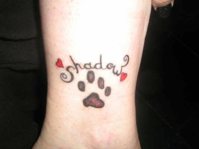 tetovaža pasje šape, tetoviran scenarij in dve rdeči srčki, umetniška tetovaža