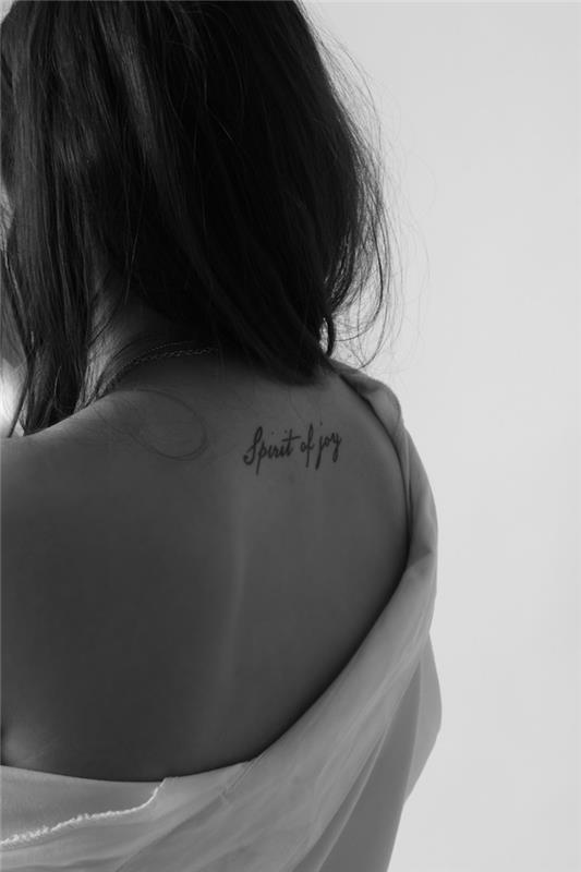 navdihujoče besede, vgravirane na koži, ženska tetovaža s črnimi črkami, bela in črna fotografija