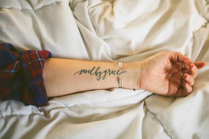 kadın dövmesi, ilham verici kelimeler tasarımı ile kol üzerine mürekkep çizimi, kadınlar için metalik bilezik