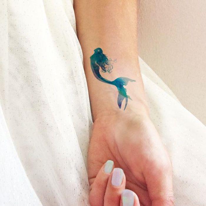 tetovaža turkizne sirene, bela manikura, akvarelna tetovaža, ženski model tetovaže