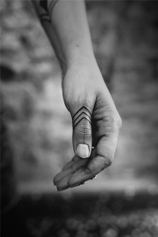 model tetovaže, risba s črnilom na prstih in rokah s plemenskim dizajnom in trikotnimi vzorci