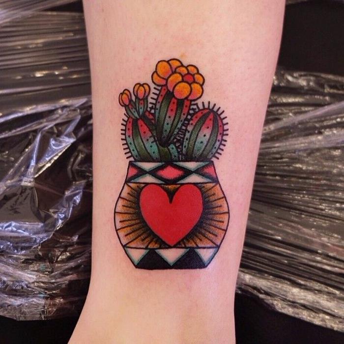 spalvinga tatuiruotė, kaktusas su oranžinėmis gėlėmis, puodas su raudona širdimi ir geometriniais raštais