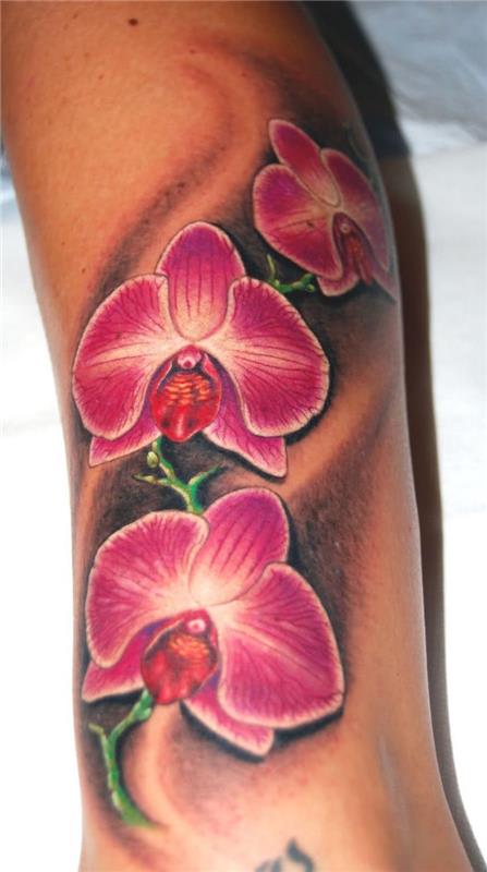 rožinė orchidėjų tatuiruotė ant moters blauzdos