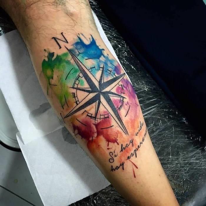 Idea per un tatuaggio braccio uomo con disegno colorato di una bussola con scritta