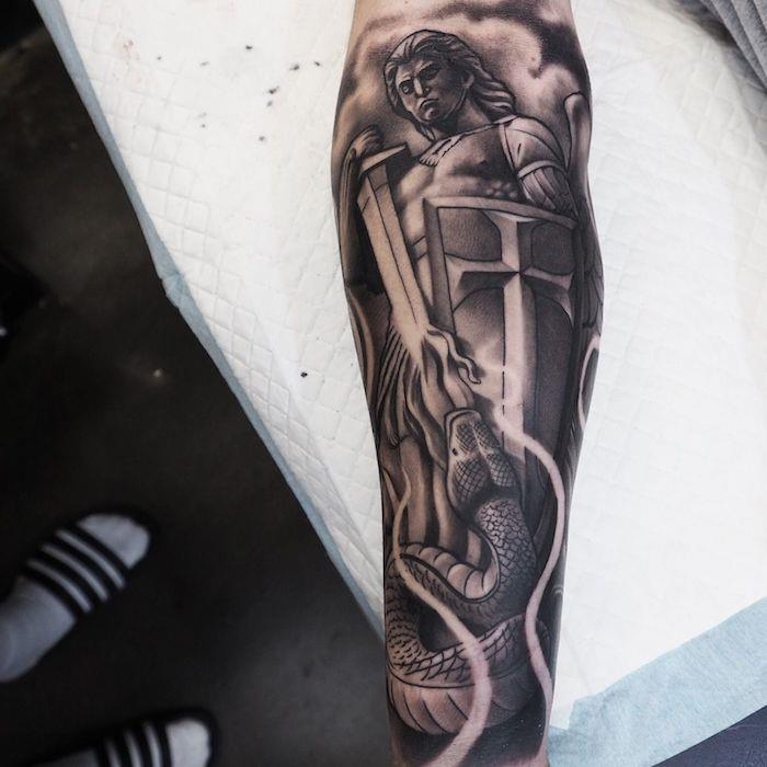 Idea tatuaggi uomo e il disegno di uno che uccide un serpente con la spada