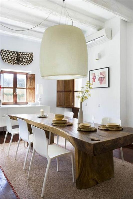 Sala da pranzo con un tavolo di design and sedie bianche, decorare con un lampadario bianco