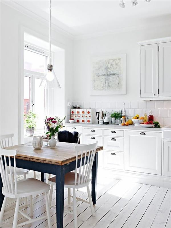 Arredamento cucina con mobili di colore bianco e un tavolo da pranzo rustico con sedie bianche