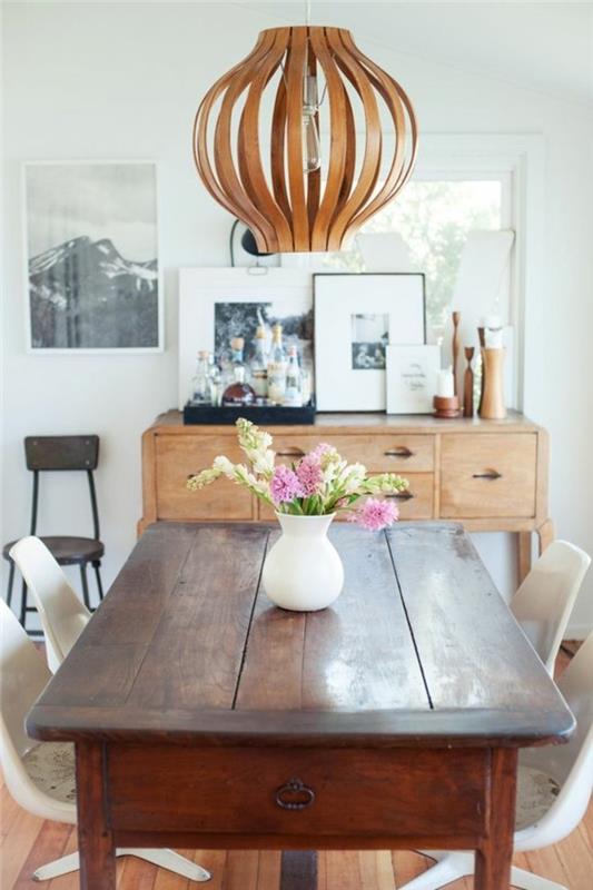 Arredare la sala da pranzo con un tavolo di legno, decorare con un lampadario a sospensione