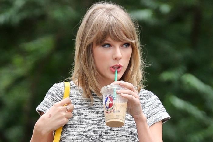 Vurgular ve vurgular ile koyu sarı renkte patlama ile orta saçlı Taylor Swift saç modeli