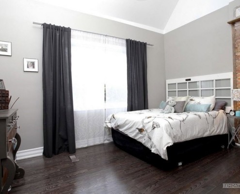 Laminado oscuro y paredes de color gris claro en el dormitorio.