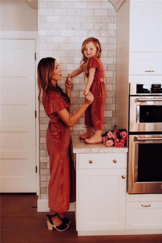 Modern beyaz mutfak, kadın kırmızı kıyafeti, kızıyla aynı görünerek iyi giyiniyor