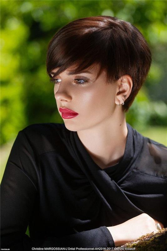 trendovska kratka rjava frizura s šiška ženska z elegantno črno obleko