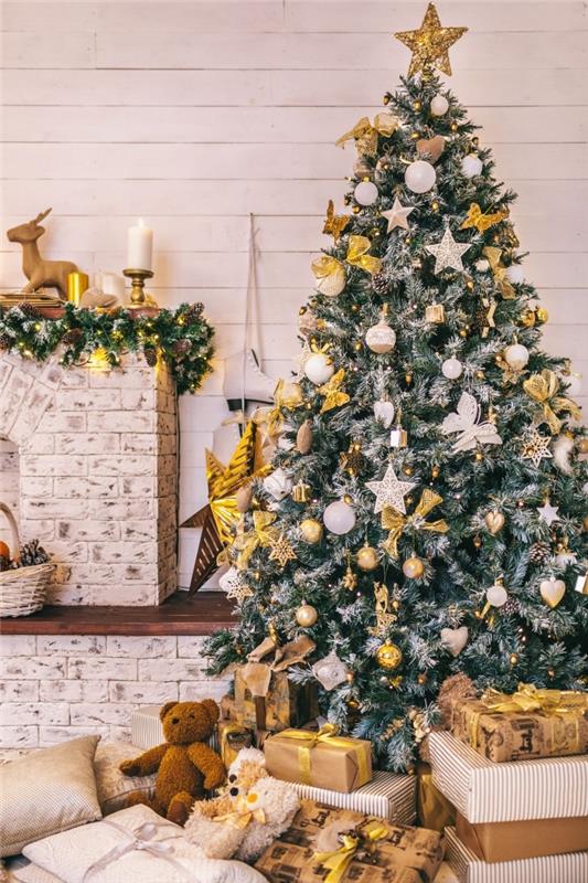 Noel dekorasyonu şık iç mekan, yıldızlar ve altın kurdelelerle süslenmiş karlı dalları olan büyük yapay ağaç