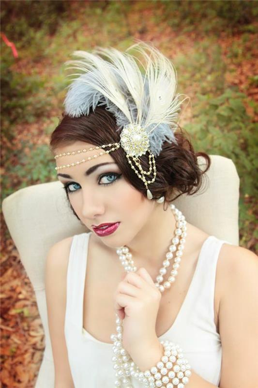 Obleka Charleston, kremna obleka z naramnicami, nakit na glavi s perjem in biserna ogrlica