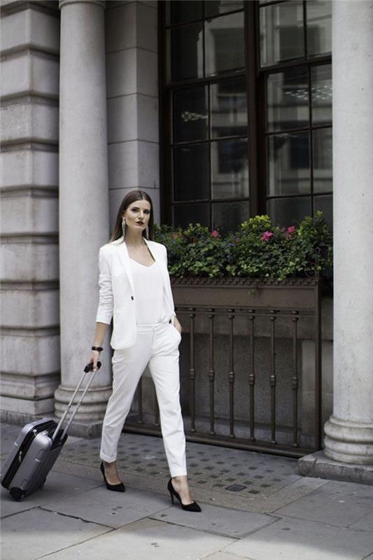 enobarvno eleganten videz v beli barvi, ženska hlačna obleka s preprostim in rafiniranim krojem, povezana s črnimi črpalkami in dolgimi uhani