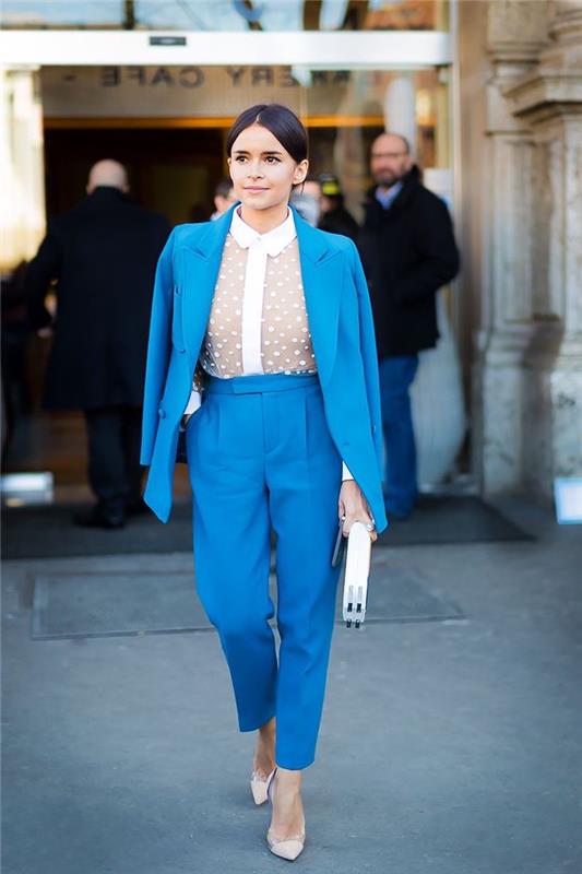 elegantna vizija v elegantnih ženskih hlačah z visokim pasom v turkizno modri barvi in ​​ujemajočem se jopiču v kombinaciji z belo majico s tančico
