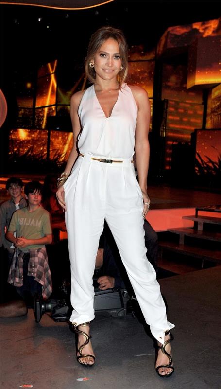 moteriška ir elegantiška Jennifer Lopez išvaizda baltame kombinezone su V formos iškirpte ir juodais sandalais