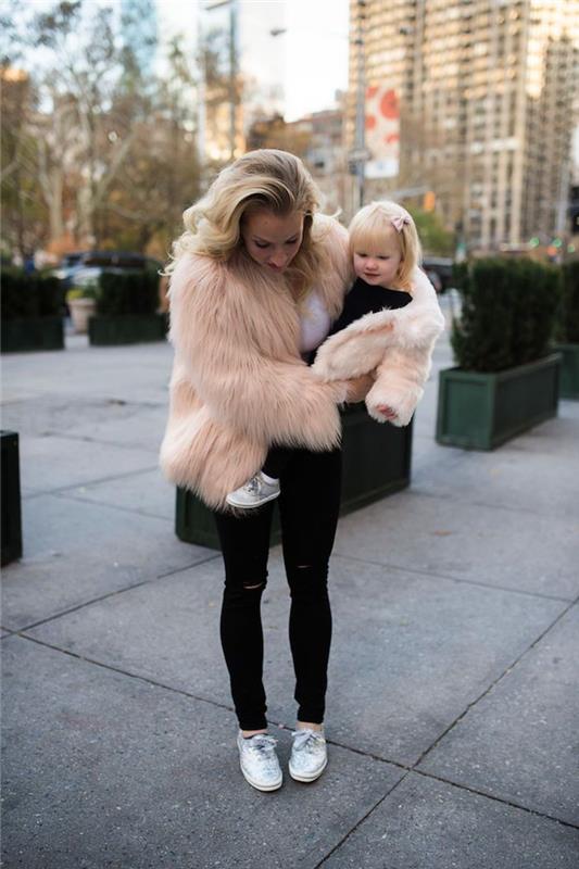 Rožinė dirbtinio kailio striukė ir juodi džinsai, motinos dukros aprangos idėja, puikiai harmoningos nuotraukos