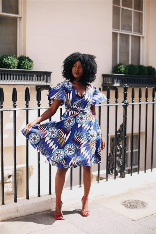 prašmatni ir moteriška išvaizda šiuolaikiškoje afrikietiškoje suknelėje su trumpomis, šiek tiek išskleistomis rankovėmis, apvyniokite modelį modernioje nugarinėje su grafiniais Afrikos raštais