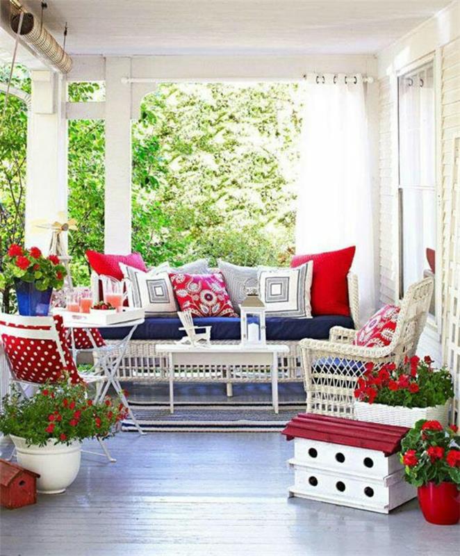 beyaz bahçe mobilyaları ve çok sayıda kırmızı ve beyaz minderli kapalı teraslar
