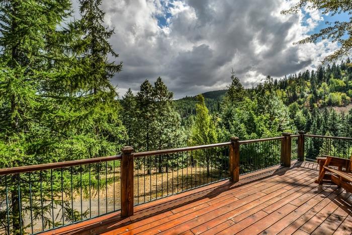 zunanjost planinske koče, zelene jelke, nebo z belimi oblaki, eksotična lesena terasa