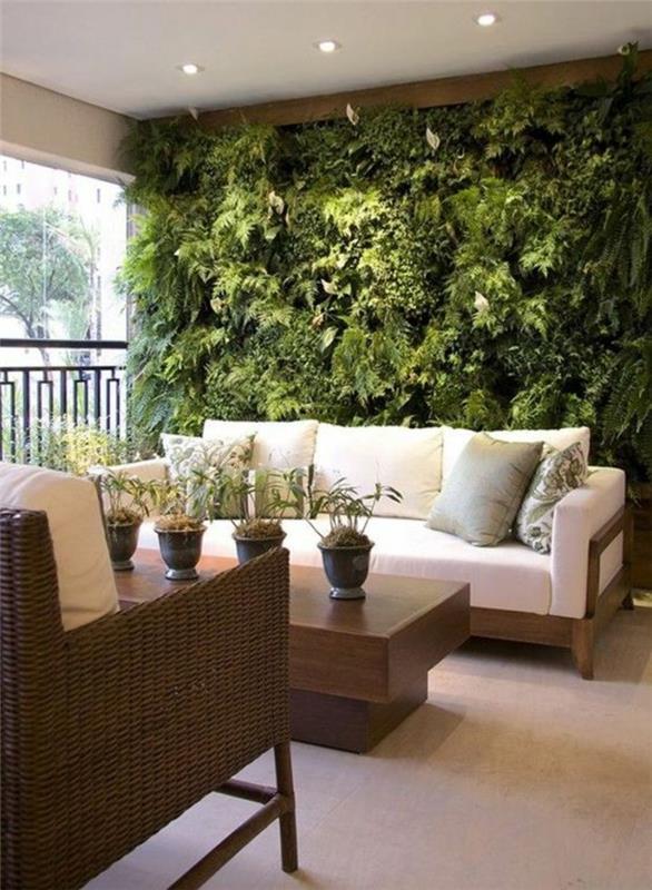 beyaz tavanlı ve küçük aydınlatma armatürlü yeşil bitkilerin tüm duvarına sahip korunaklı kapalı teraslar gizli ışık