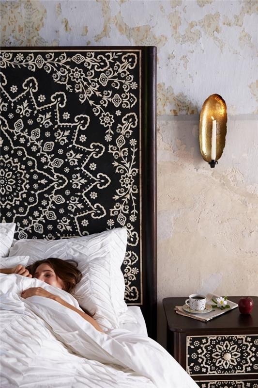 primer dekoracije postelje v boemskem elegantnem slogu z velikim vzglavjem iz temnega lesa z obliko bele mandale