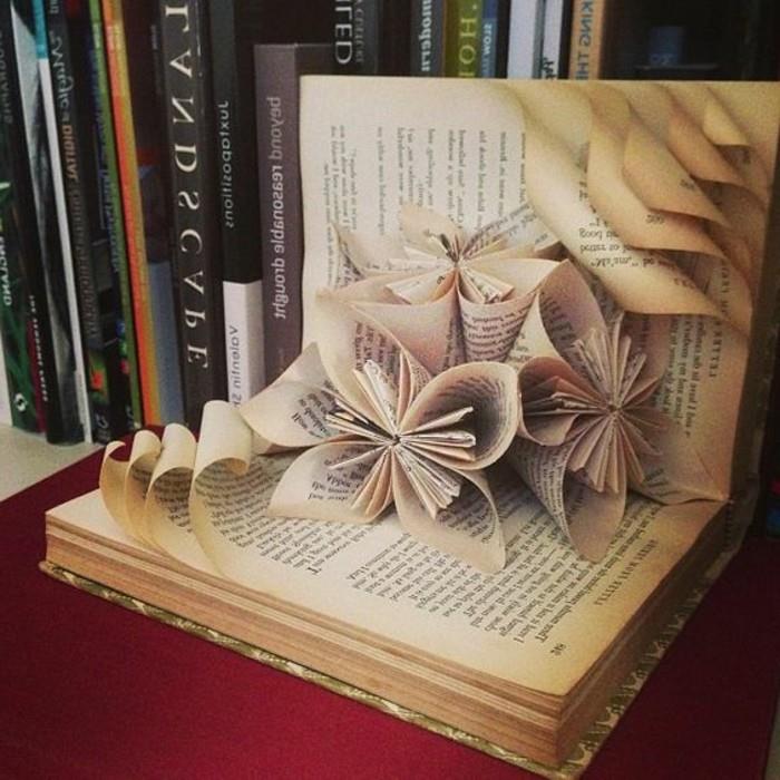 odprta knjiga, ki vsebuje tri rože iz njenih strani, več drugih strani z zavitimi robovi