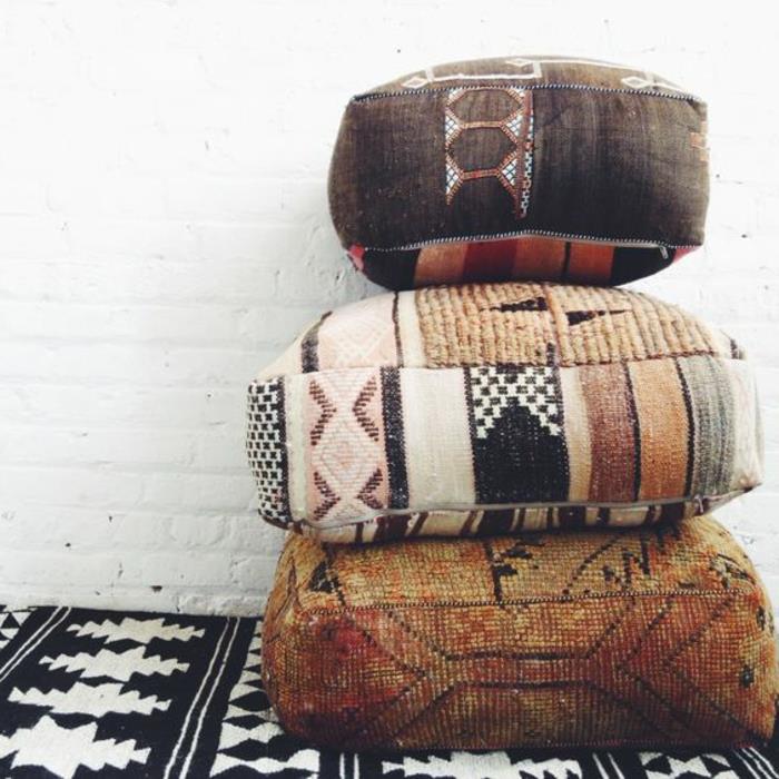 etniniai audiniai, etninės kvadratinės pagalvėlės, juodos ir baltos spalvos kilimas, balta plytų siena